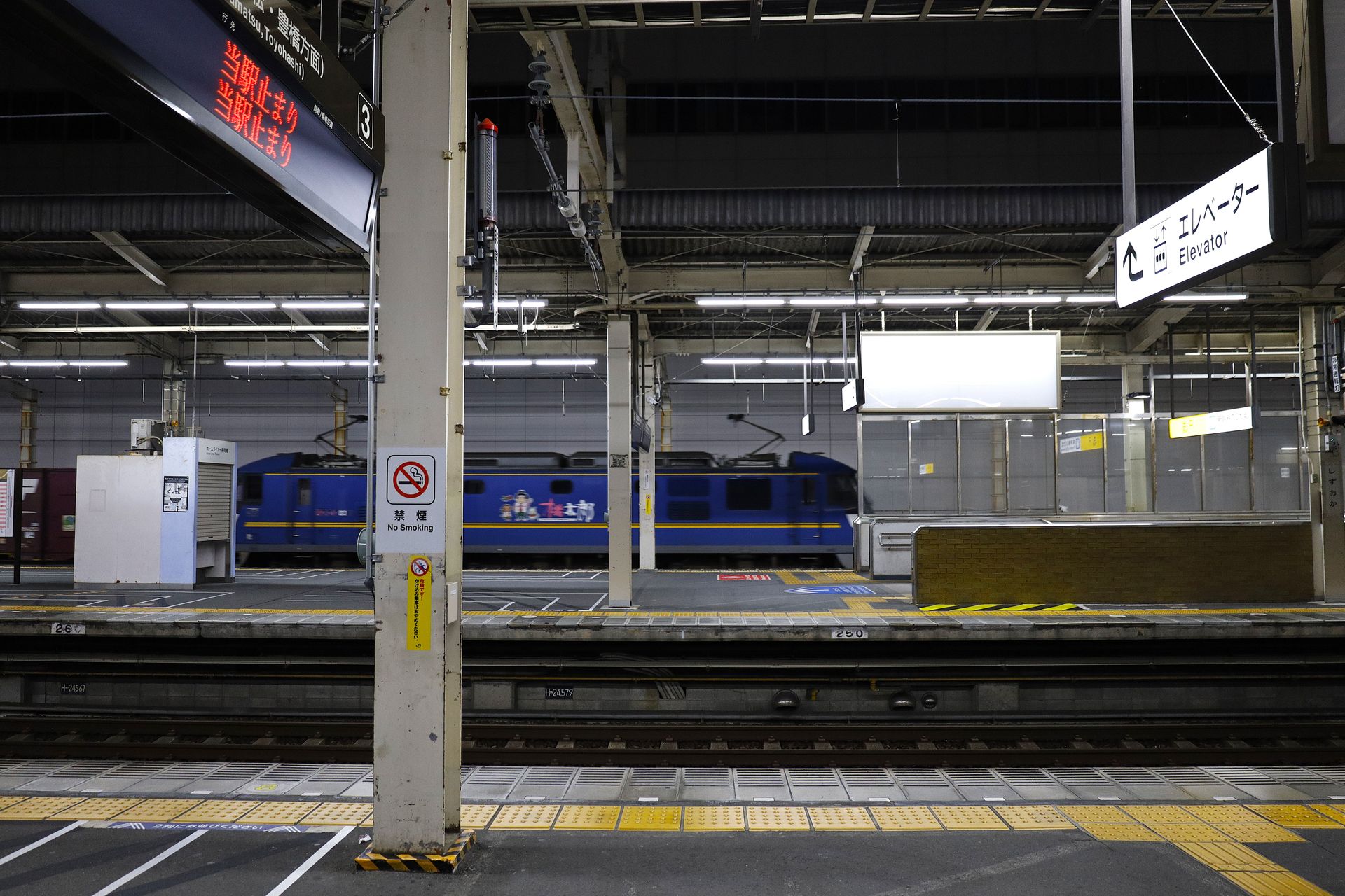 照明に照らされた深夜の鉄道駅のホームと停車中の車両